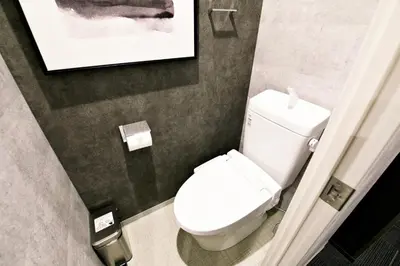 a bathroom with a toilet and a picture on the wall at Regalo Shibaura 501 - Vacation STAY 06260v in Tokyo