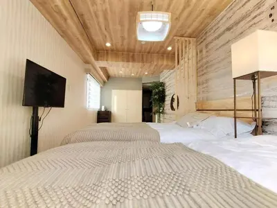 a bedroom with three beds and a flat screen tv at G91\u65b0\u5bbf\u6700\u4e2d\u5fc3 \u6771\u65b0\u5bbf\u7ad95\u5206-Shinjuku center 5 mins to St, Max 5P \u65b0\u5bbf \u6d89\u8c37 \u8868\u53c2\u9053 \u6c60\u888b \u4e0a\u91ce \u4ee3\u4ee3\u6728 \u94f6\u5ea7 \u539f\u5bbf in Tokyo