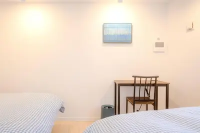 a bedroom with a bed and a table and a chair at Jessica House in Tokyo