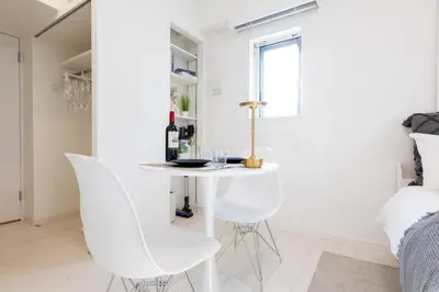 a white dining room with white chairs and a table at LIVCITY Kinshicho 302 in Tokyo