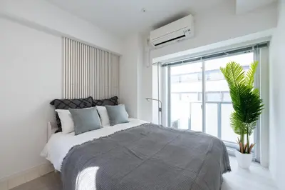 a bedroom with a large bed and a large window at LIVCITY Kinshicho 302 in Tokyo