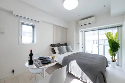 a white bedroom with a bed and a table at LIVCITY Kinshicho 402 in Tokyo