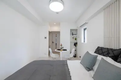 a white room with a bed and a table at LIVCITY Kinshicho 402 in Tokyo