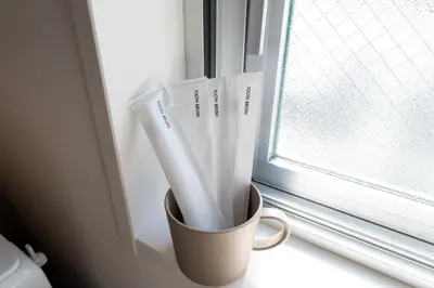 a cup sitting on a window sill with toothbrushes at LIVCITY Kinshicho 402 in Tokyo