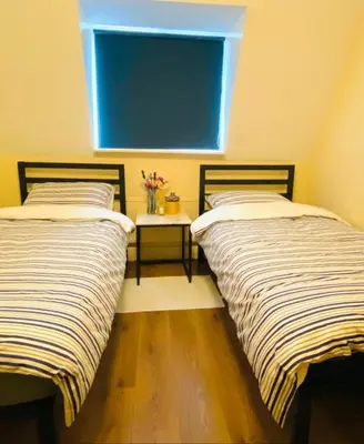 two beds in a room with a window and a table at The class omote in Tokyo