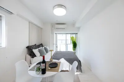 a white living room with a table and chairs at LIVCITY Kinshicho 902 in Tokyo