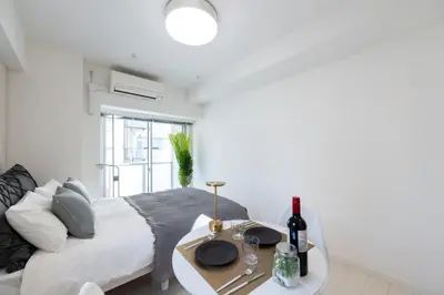 a bedroom with a bed and a table with wine bottles at LIVCITY Kinshicho 902 in Tokyo