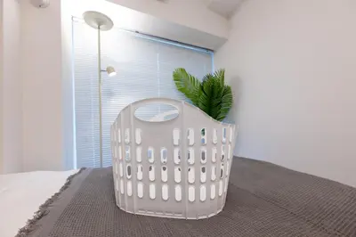 a white chair sitting on a bed in a room at LIVCITY Kinshicho 902 in Tokyo