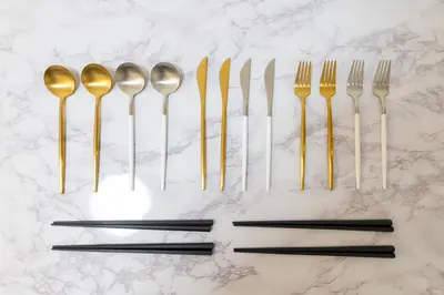 a group of gold forks and spoons on a counter at LIVCITY Kinshicho 902 in Tokyo