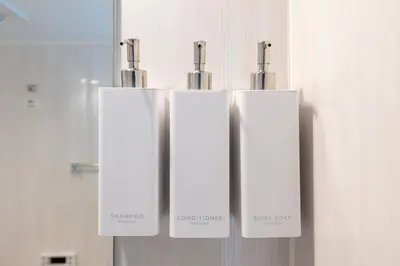 a group of three white stalls in a bathroom at LIVCITY Kinshicho 602 in Tokyo
