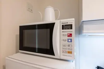 a microwave oven sitting on top of a refrigerator at LIVCITY Kinshicho 602 in Tokyo