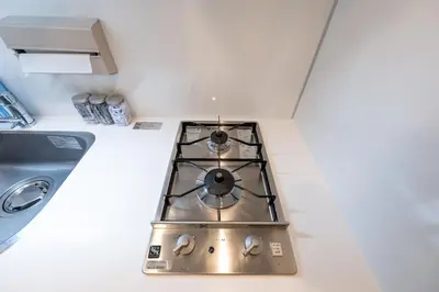 a stove top oven in a kitchen next to a sink at LIVCITY Kinshicho 602 in Tokyo
