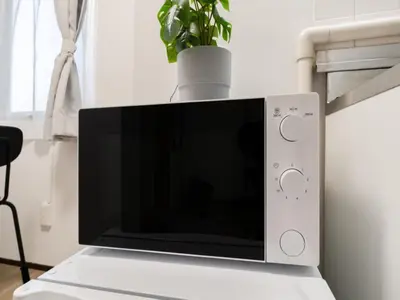 a laptop computer sitting on a table with a plant at Shibuya, 3min walk Ebisu Sta, 2min Harajuku Sta,Queen bed in Tokyo