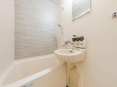 a white bathroom with a sink and a bath tub at Shibuya, 3min walk Ebisu Sta, 2min Harajuku Sta,Queen bed in Tokyo