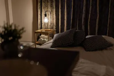 a bedroom with a bed with pillows and a lamp at Ikebukuro Base in Tokyo