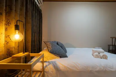 a bedroom with a bed and a table with towels on it at Ikebukuro Base in Tokyo
