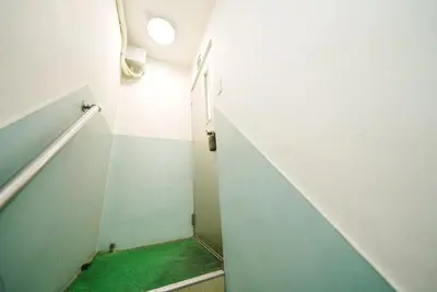 a stairway with a green carpet in a room at Ikebukuro Base in Tokyo