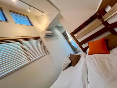 a small room with a bed and two windows at \u843d\u5408\u30df\u30ea\u30aa\u30f3\u30cf\u30a6\u30b9 in Tokyo