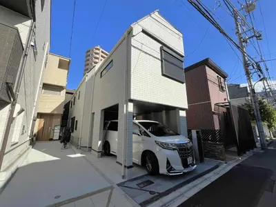 a white car parked in front of a building at \u843d\u5408\u30df\u30ea\u30aa\u30f3\u30cf\u30a6\u30b9 in Tokyo