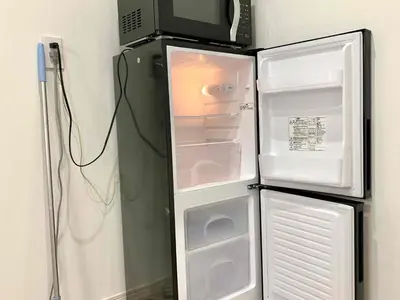 a refrigerator with its door open and a microwave at \u843d\u5408\u30df\u30ea\u30aa\u30f3\u30cf\u30a6\u30b9 in Tokyo