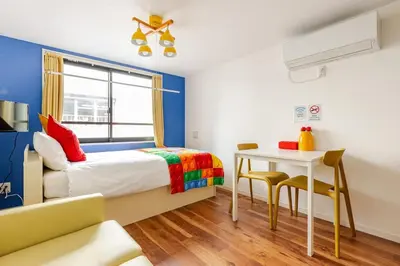 a bedroom with a bed and a table with chairs at jtr\u6d45\u8349\u6a4b402 in Tokyo