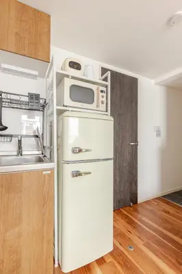 a kitchen with a microwave on top of a refrigerator at jtr\u6d45\u8349\u6a4b402 in Tokyo