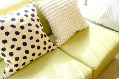 two pillows sitting on top of a yellow couch at \u30af\u30ec\u30a2\u30fc\u30ec\u795e\u697d\u5742\u30b2\u30b9\u30c8\u30cf\u30a6\u30b9105\u53f7\u5ba4 - \u6771\u4eac\u89b3\u5149\u306b\u4fbf\u5229 - \u725b\u8fbc\u795e\u697d\u5742\u99c5\u304b\u3089\u5f92\u6b693\u5206 in Tokyo