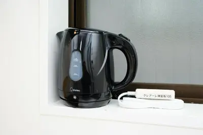 a black coffee pot sitting on a shelf at \u30af\u30ec\u30a2\u30fc\u30ec\u795e\u697d\u5742\u30b2\u30b9\u30c8\u30cf\u30a6\u30b9105\u53f7\u5ba4 - \u6771\u4eac\u89b3\u5149\u306b\u4fbf\u5229 - \u725b\u8fbc\u795e\u697d\u5742\u99c5\u304b\u3089\u5f92\u6b693\u5206 in Tokyo