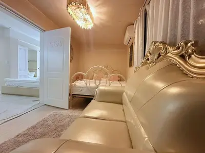 a living room with a gold couch and a bedroom at Reimi Mondo703 in Tokyo
