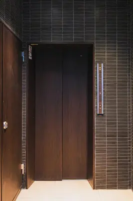 a large wooden door in a building at Luxury Stay near Azabudai Hills and Tokyo Tower, 2-Bedroom Apartment in Tokyo