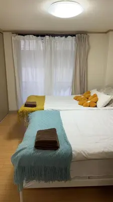 a bedroom with a large bed with towels on it at 21\u89c2\u666f\u9633\u53f0\u623f \u5927\u7a7a\u95f4\u536b\u6d74\u53a8\u623f \u6d17\u8863\u673a \u8f66\u7ad9\u6b65\u884c3\u5206\u949f \u4e0a\u91ce \u6d89\u8c37 \u8fea\u58eb\u5c3c \u673a\u573a \u5750\u8f66\u76f4\u8fbe in Tokyo