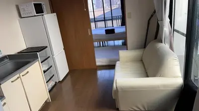 a living room with a white couch and a kitchen at 41\u89c2\u666f\u9633\u53f0\u623f \u5927\u7a7a\u95f4\u536b\u6d74\u53a8\u623f \u6d17\u8863\u673a \u8f66\u7ad9\u6b65\u884c3\u5206\u949f \u4e0a\u91ce \u6d89\u8c37 \u8fea\u58eb\u5c3c \u673a\u573a \u5750\u8f66\u76f4\u8fbe in Tokyo