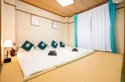a bedroom with a large white bed with blue pillows at 22\u89c2\u666f\u9633\u53f0\u623f \u5927\u7a7a\u95f4\u536b\u6d74\u53a8\u623f \u6d17\u8863\u673a \u8f66\u7ad9\u6b65\u884c3\u5206\u949f \u4e0a\u91ce \u6d89\u8c37 \u8fea\u58eb\u5c3c \u673a\u573a \u5750\u8f66\u76f4\u8fbe in Tokyo
