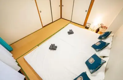 a room with two beds with blue and white pillows at 22\u89c2\u666f\u9633\u53f0\u623f \u5927\u7a7a\u95f4\u536b\u6d74\u53a8\u623f \u6d17\u8863\u673a \u8f66\u7ad9\u6b65\u884c3\u5206\u949f \u4e0a\u91ce \u6d89\u8c37 \u8fea\u58eb\u5c3c \u673a\u573a \u5750\u8f66\u76f4\u8fbe in Tokyo