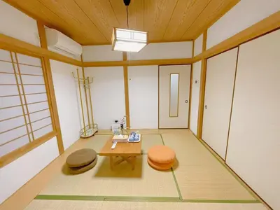 a room with a table and two mats on the floor at \u53cb\u7e01\u306e\u5bb6Destined Bonds Haven\u5317\u5343\u4f4f in Tokyo
