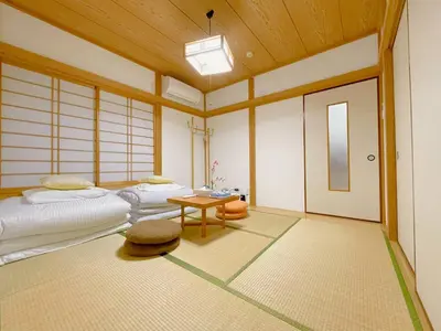 a room with two beds and a table at \u53cb\u7e01\u306e\u5bb6Destined Bonds Haven\u5317\u5343\u4f4f in Tokyo
