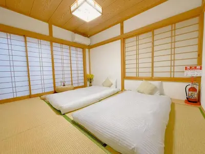 two twin beds in a room with windows at \u53cb\u7e01\u306e\u5bb6Destined Bonds Haven\u5317\u5343\u4f4f in Tokyo