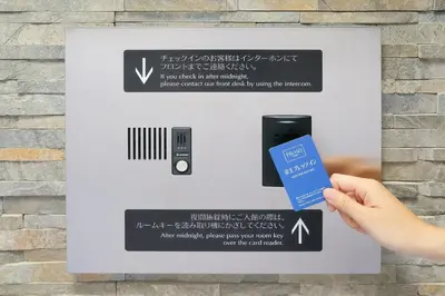 a person holding a credit card and a remote control at Keio Presso Inn Akasaka in Tokyo