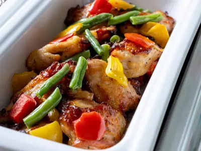 a styrofoam container of food with chicken and vegetables at Keio Presso Inn Akasaka in Tokyo