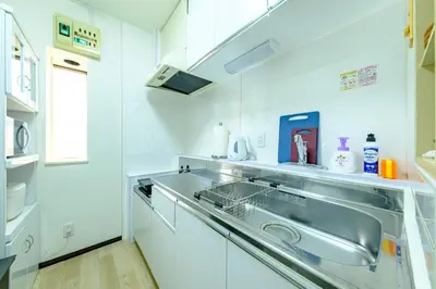 a white kitchen with a sink and a counter at \u3055\u304f\u3089\u30cf\u30a6\u30b9 - Sakura house - \u5e83\u3005\u5feb\u9069 \u6700\u59276\u540d\u6ede\u5728\u53ef in Tokyo