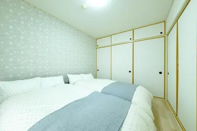 a bedroom with a white bed and white cabinets at \u3055\u304f\u3089\u30cf\u30a6\u30b9 - Sakura house - \u5e83\u3005\u5feb\u9069 \u6700\u59276\u540d\u6ede\u5728\u53ef in Tokyo