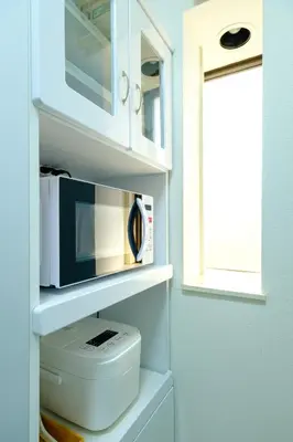 a bathroom with a toilet with a microwave and a window at \u3055\u304f\u3089\u30cf\u30a6\u30b9 - Sakura house - \u5e83\u3005\u5feb\u9069 \u6700\u59276\u540d\u6ede\u5728\u53ef in Tokyo