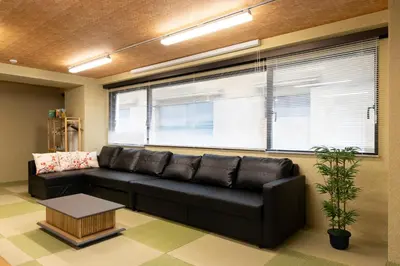 a living room with a black leather couch and a window at SLEEPLAB \u795e\u697d\u5742 -Kagurazaka- in Tokyo