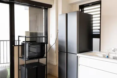 a kitchen with a black refrigerator and a sink at SLEEPLAB \u795e\u697d\u5742 -Kagurazaka- in Tokyo