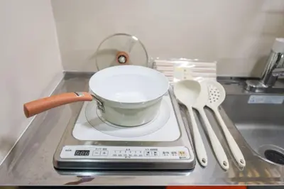 a pot on a stove with a strainer and spoons at \u738b102\u6574\u5957\u79c1\u4eba\u536b\u6d74\u53a8\u623f \u6d17\u8863\u673a \u8f66\u7ad9\u6b65\u884c5\u5206\u949f \u4e0a\u91ce\u7ad9\u5730\u94c1\u76f4\u8fbe in Tokyo