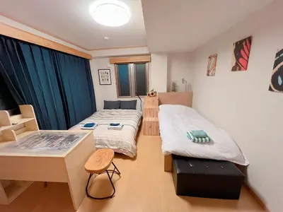 a room with two beds and a desk in it at \u8cb4\u9802\u5e9c\u90b8 \u95a2\u539f KICYO HOUSE No3 in Tokyo