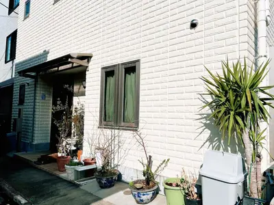 a house with potted plants in front of a building at \u8cb4\u9802\u5e9c\u90b8 \u95a2\u539f KICYO HOUSE No3 in Tokyo