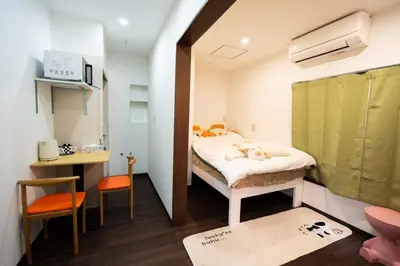 a small room with a bed and a small table at \u738b101\u6574\u5957\u79c1\u4eba\u7a7a\u95f4\u72ec\u7acb\u536b\u6d74\u53a8\u623f \u6d17\u8863\u673a \u8f66\u7ad9\u6b65\u884c5\u5206\u949f \u4e0a\u91ce\u7ad9\u5730\u94c1\u76f4\u8fbe in Tokyo