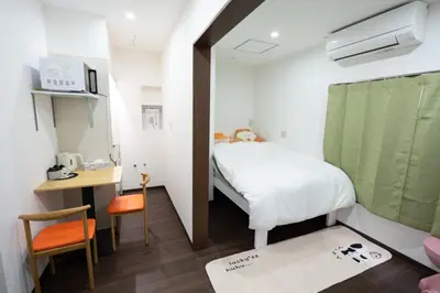 a small room with a bed and a desk with a microwave at \u738b101\u6574\u5957\u79c1\u4eba\u7a7a\u95f4\u72ec\u7acb\u536b\u6d74\u53a8\u623f \u6d17\u8863\u673a \u8f66\u7ad9\u6b65\u884c5\u5206\u949f \u4e0a\u91ce\u7ad9\u5730\u94c1\u76f4\u8fbe in Tokyo