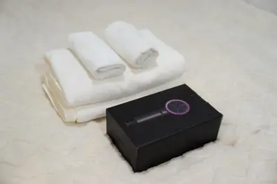 a remote control sitting next to two towels and a box at \u738b101\u6574\u5957\u79c1\u4eba\u7a7a\u95f4\u72ec\u7acb\u536b\u6d74\u53a8\u623f \u6d17\u8863\u673a \u8f66\u7ad9\u6b65\u884c5\u5206\u949f \u4e0a\u91ce\u7ad9\u5730\u94c1\u76f4\u8fbe in Tokyo